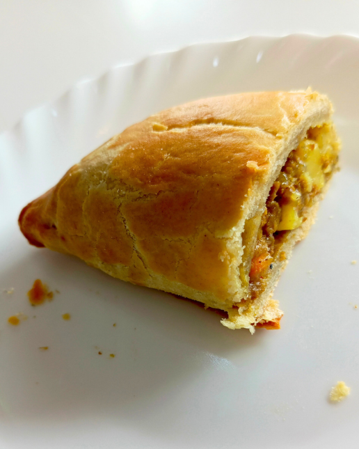 Triangular pastry on a white plate with a blurred background