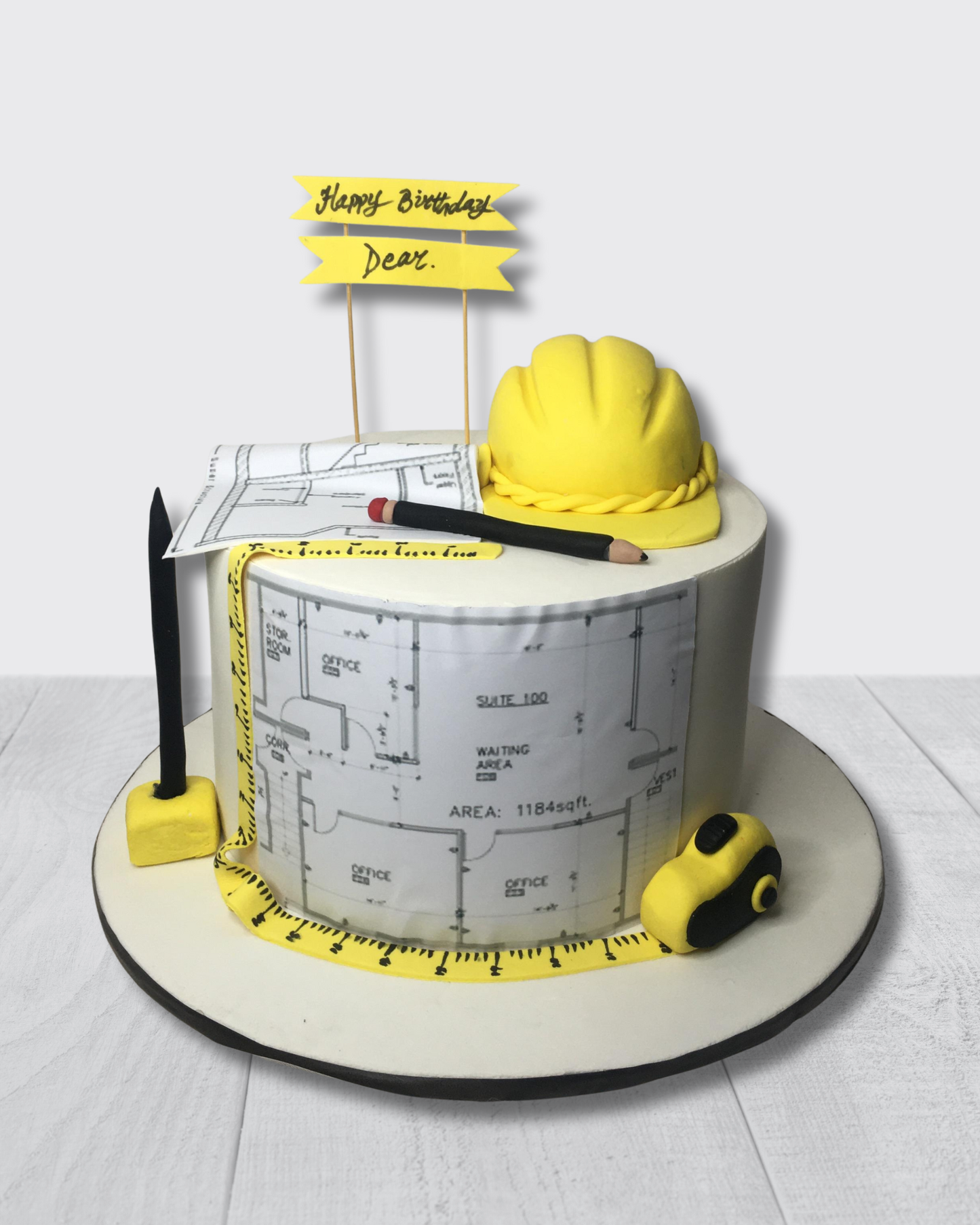 Construction-themed birthday cake with hard hat, and tools on a white background