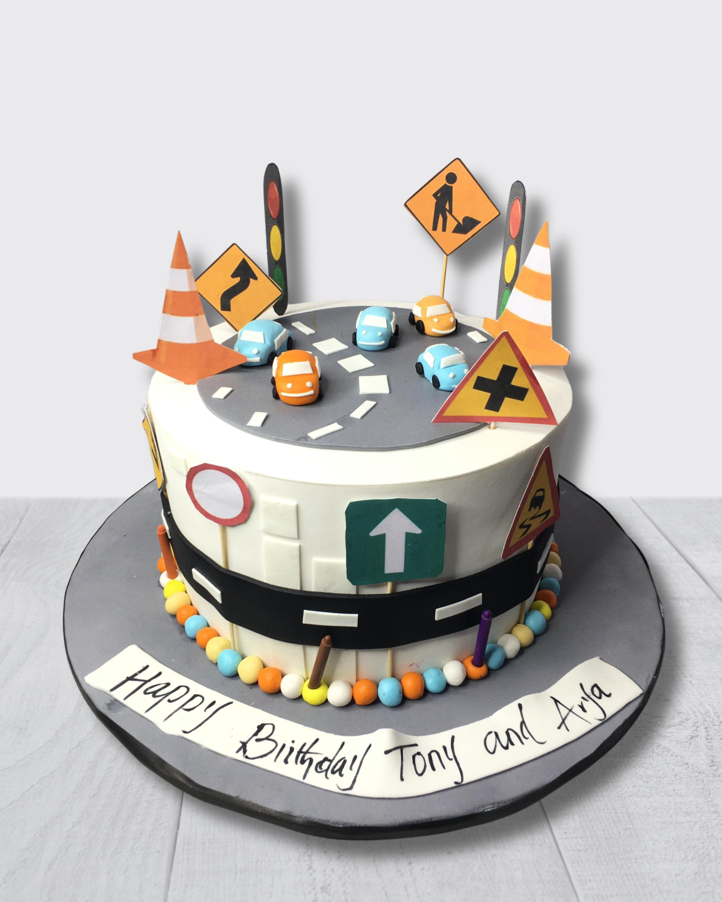 Birthday cake with traffic-themed decorations on a white background
