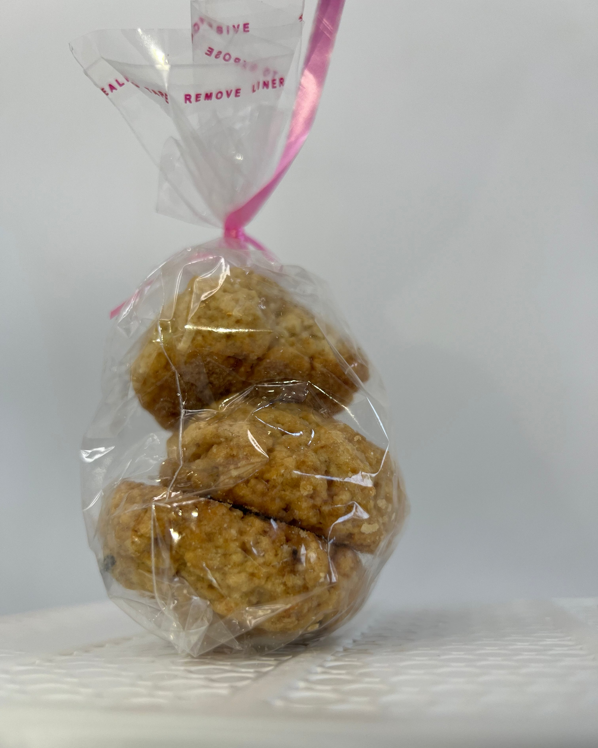 Three cookies in a clear plastic bag with a white background