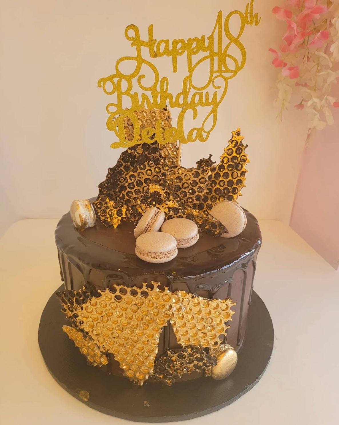 Birthday cake with gold honeycomb design and 'Happy 18th Birthday' topper on a white background