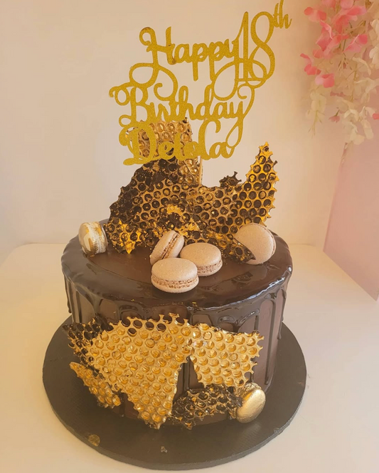 Birthday cake with gold honeycomb design and 'Happy 18th Birthday' topper on a white background