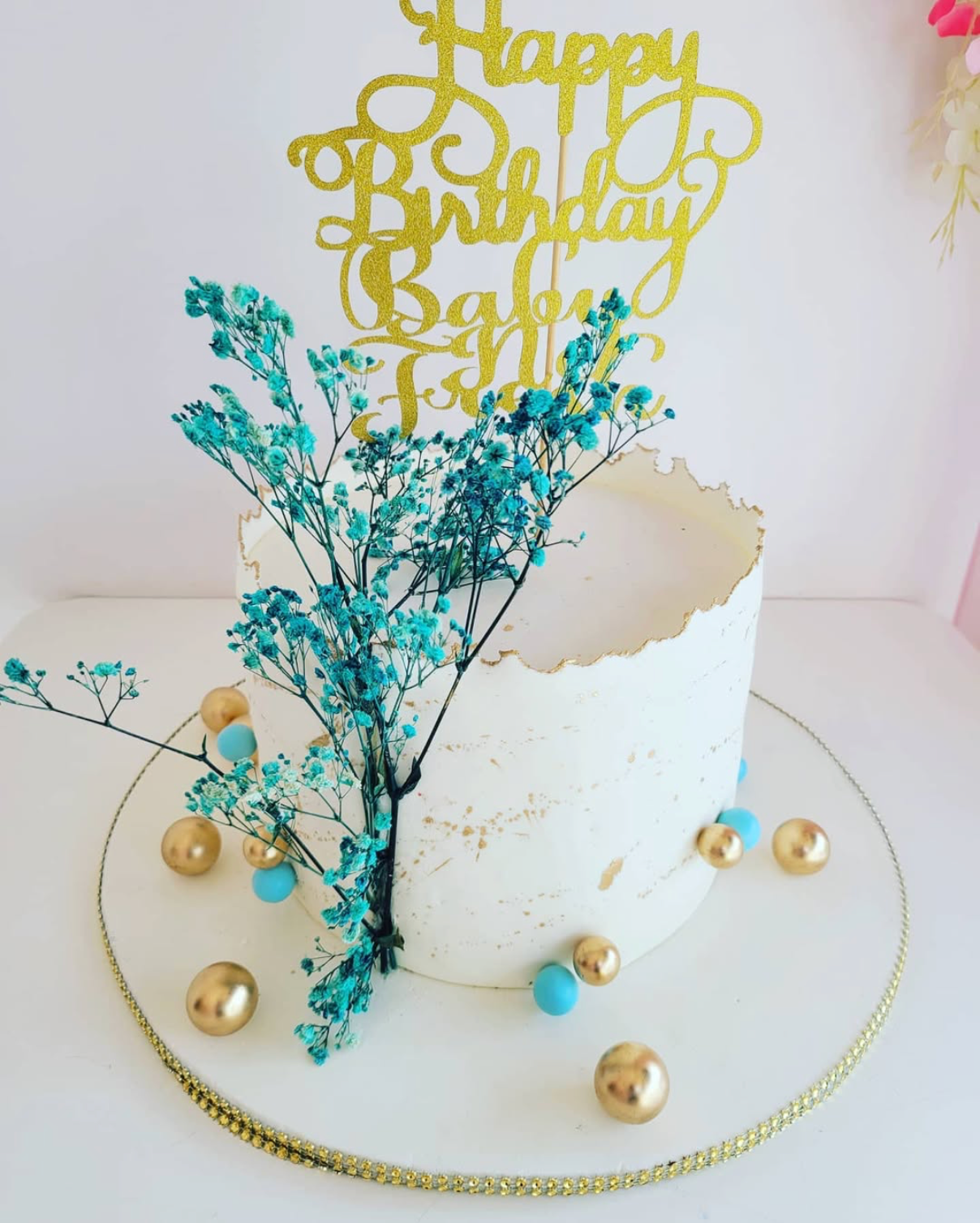 Birthday cake with decorative elements and 'Happy Birthday' topper on a white background