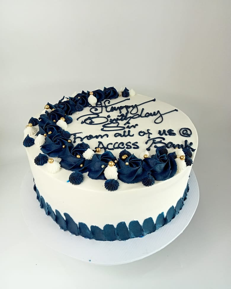 Birthday cake with navy blue flowers and white text on a gray background