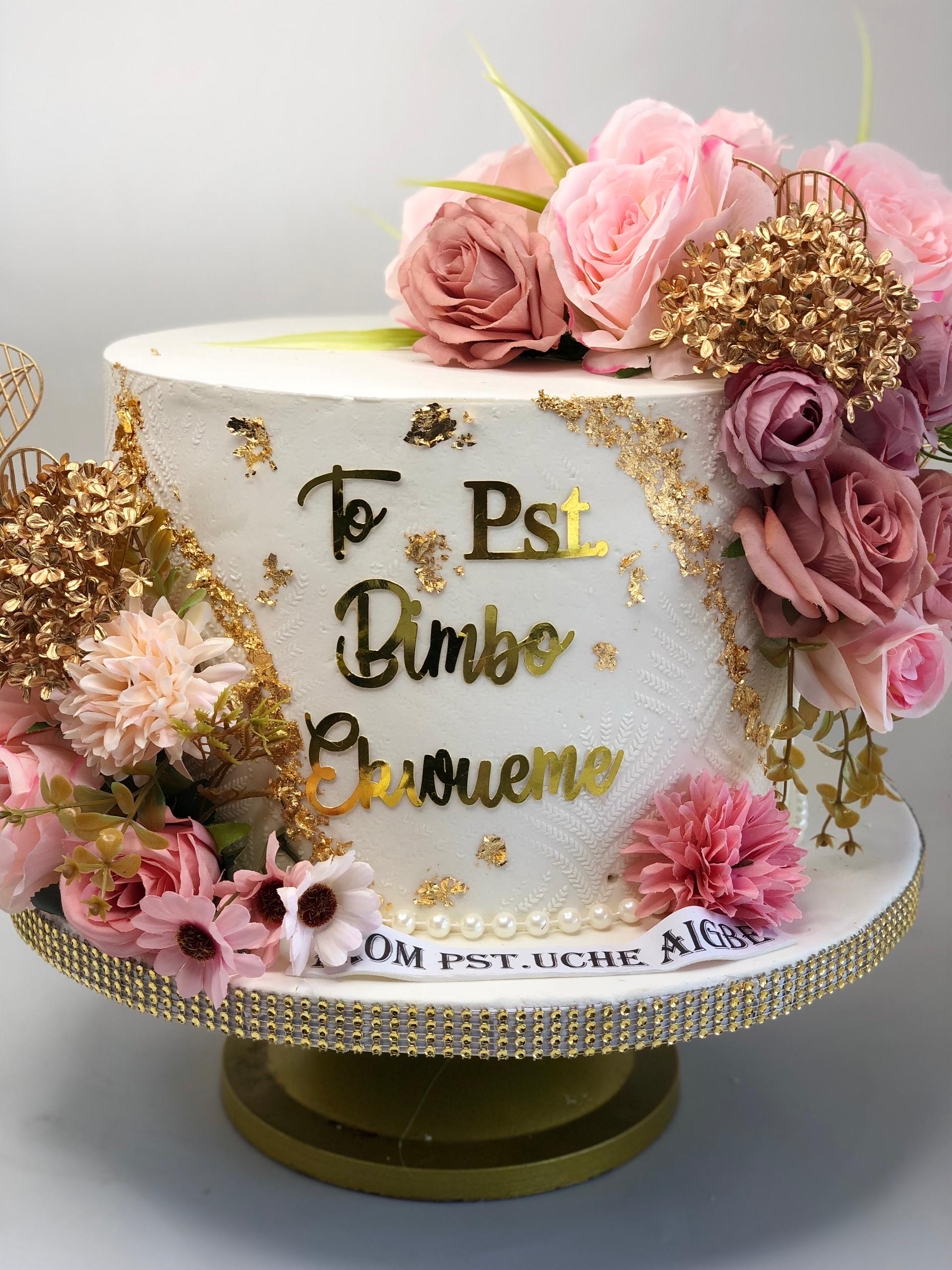 Decorative cake with flowers and gold accents on a white background