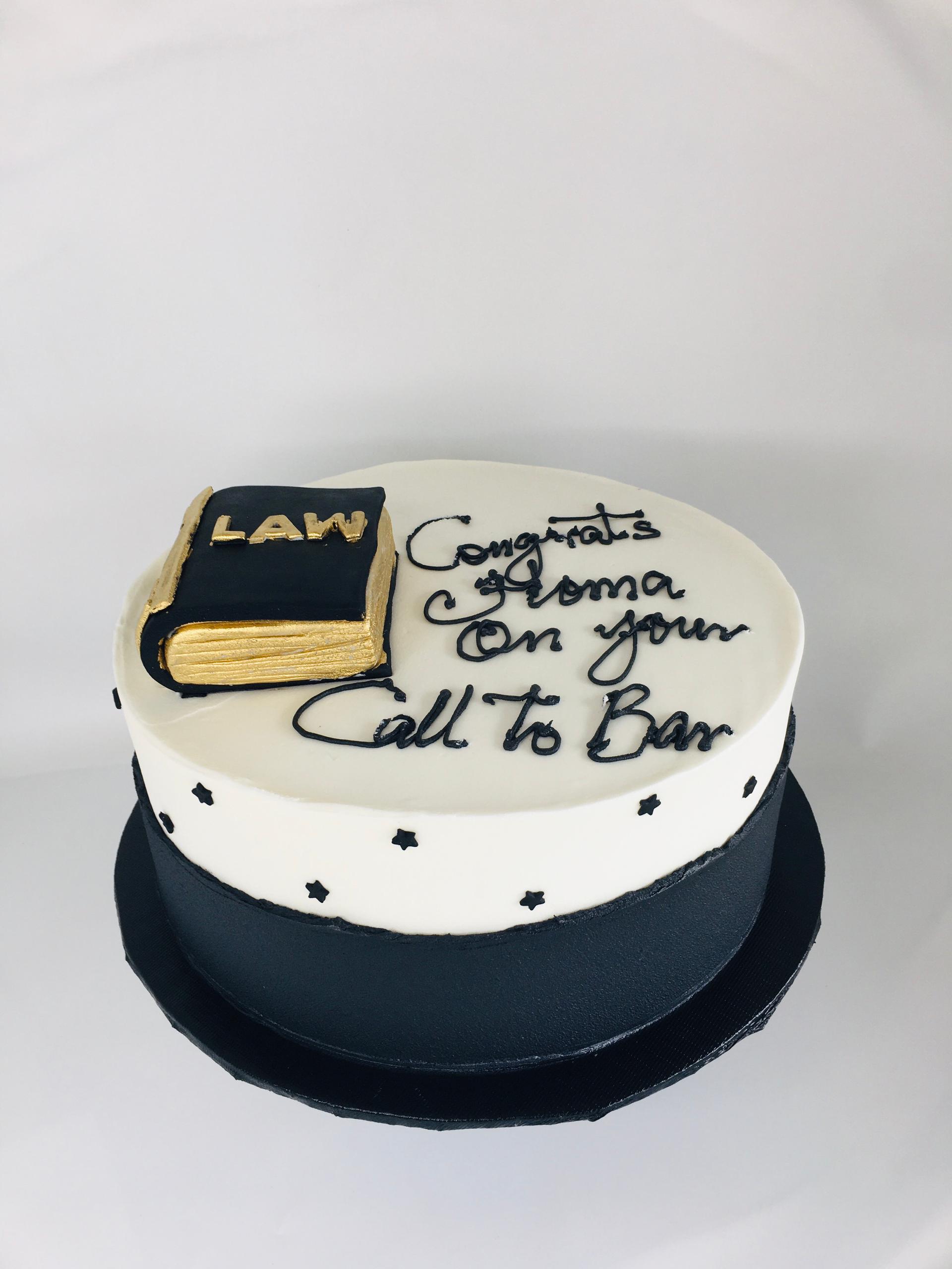 Cake with 'Law' book and 'Congrats Alma on your Call to Bar' text on a white background