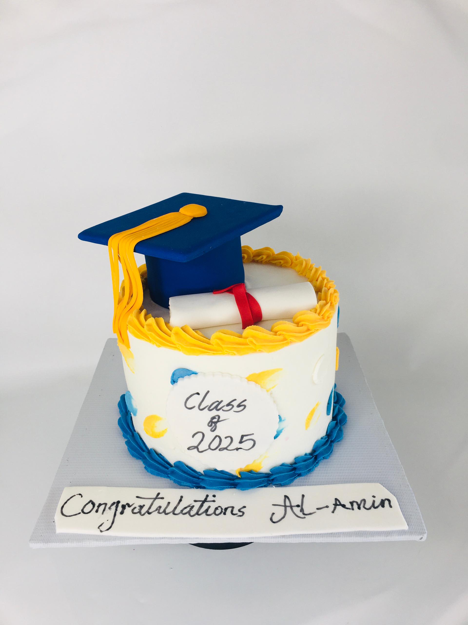Graduation-themed cake with a blue cap and yellow tassel on a white background