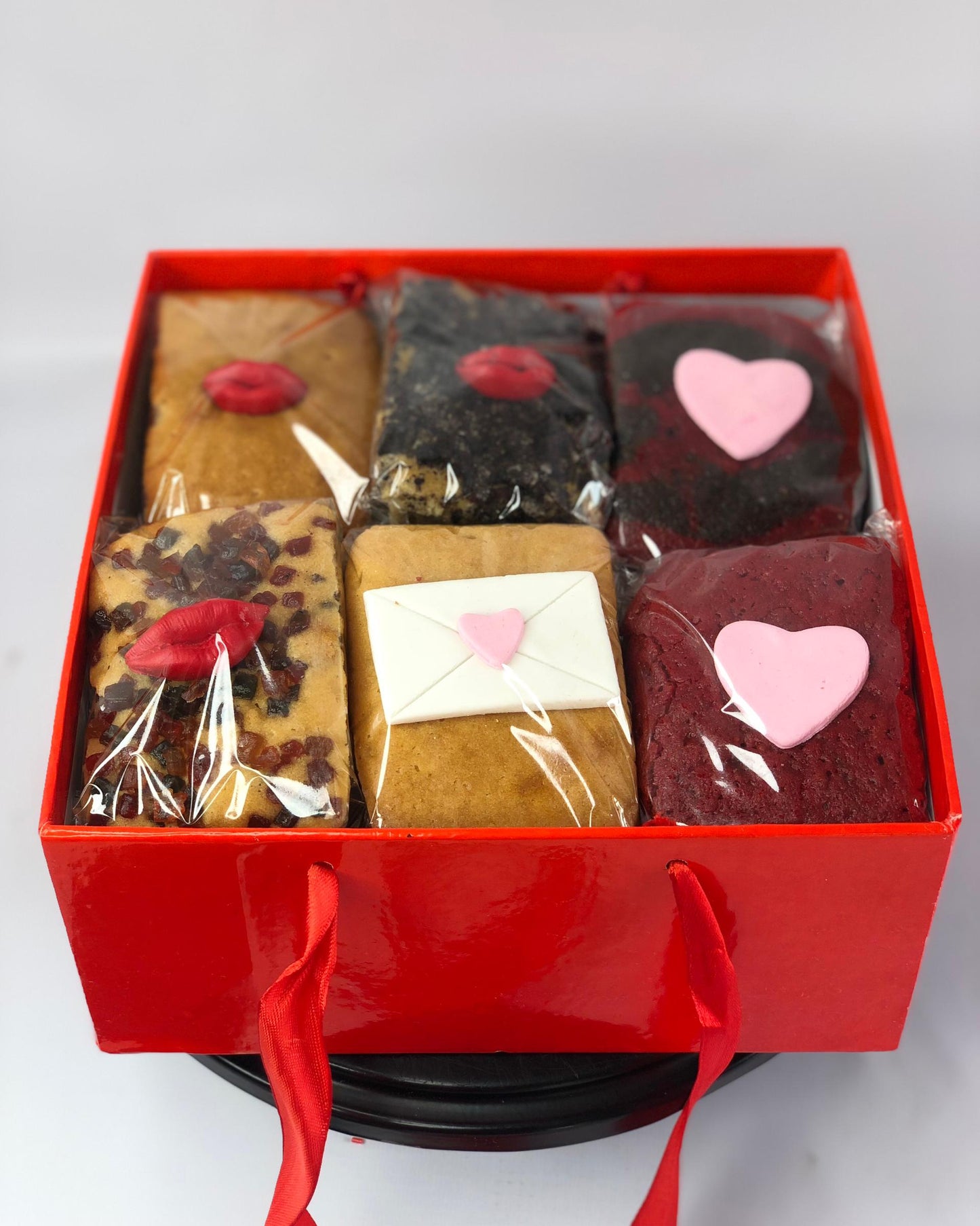 Red gift box with various types of love-themed mini loafs