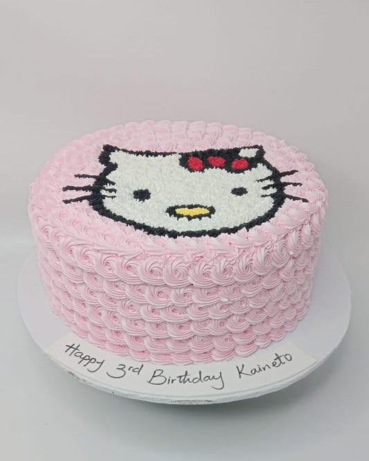 Pink birthday cake with Hello Kitty face design on a gray background